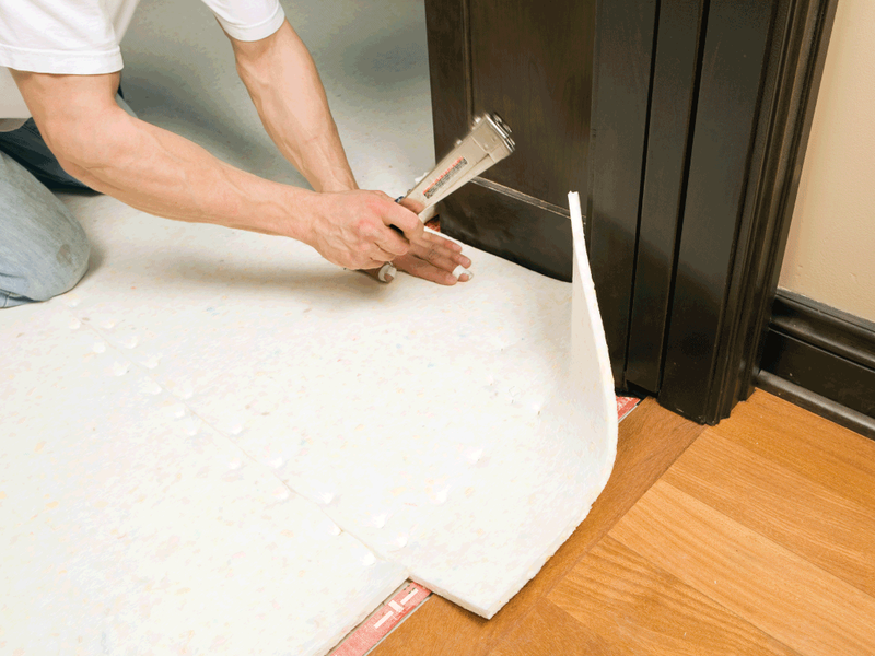 person installing carpet cushion from Anderson Tile & Carpet in Anderson, SC